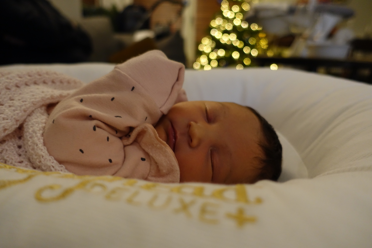 a newborn baby asleep on a cushion